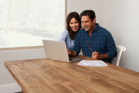 Woman and man sitting at table working on a laptop