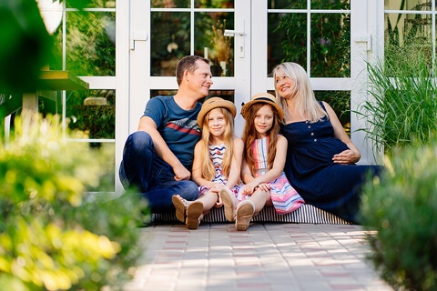 a young family with two daughters and a pregnant mother outside of home