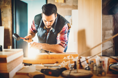 man chiseling at woodworking bench
