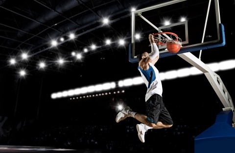 Young man slam dunking a basketball