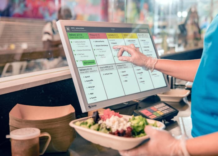 a restaurant worker using a Clover Kitchen Display