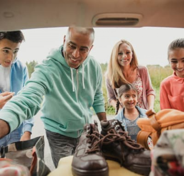 A family unpacking the trunk of their car