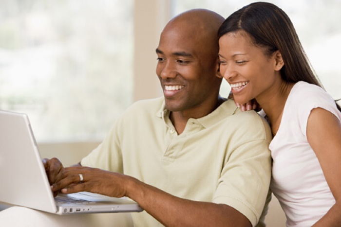 a happy couple on their home computer