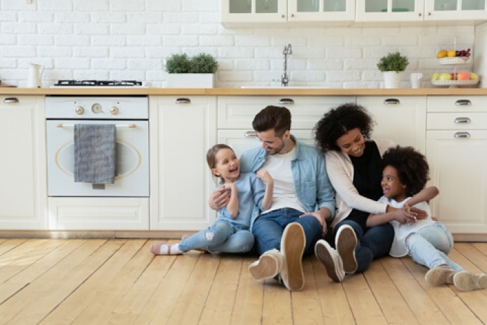 a happy family sitting together on the floor of their newly remodeled kitchen