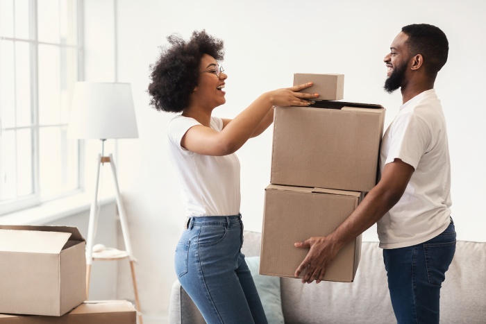 A happy African-American couple packs moving boxes together in anticipation of moving to a new home.