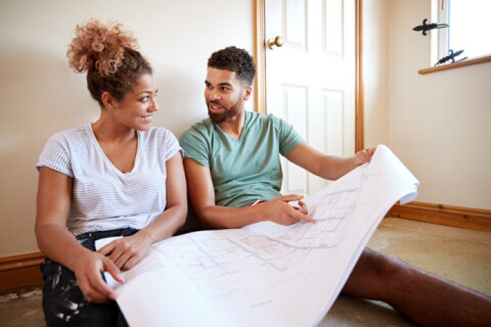 couple looking at blue print plans for their home renovation