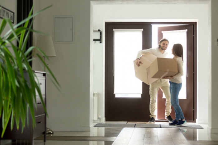 Couple moving boxes into their new home