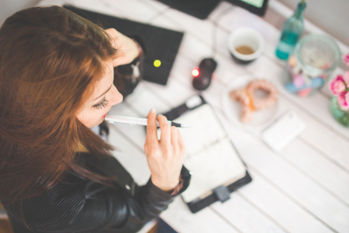 woman at table writing in planner