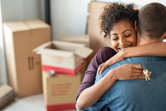 Young couple getting the keys to their first home after following first time home buyer tips