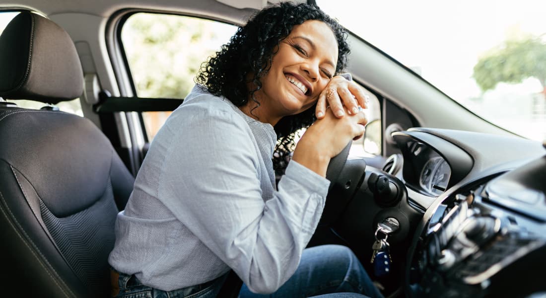 Woman smiling in the driver's seat of her car