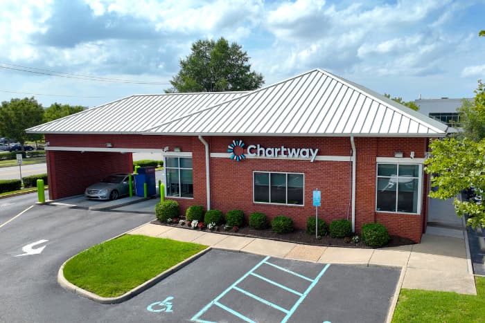 a red brick building with an entrance on the side for drive thru banking