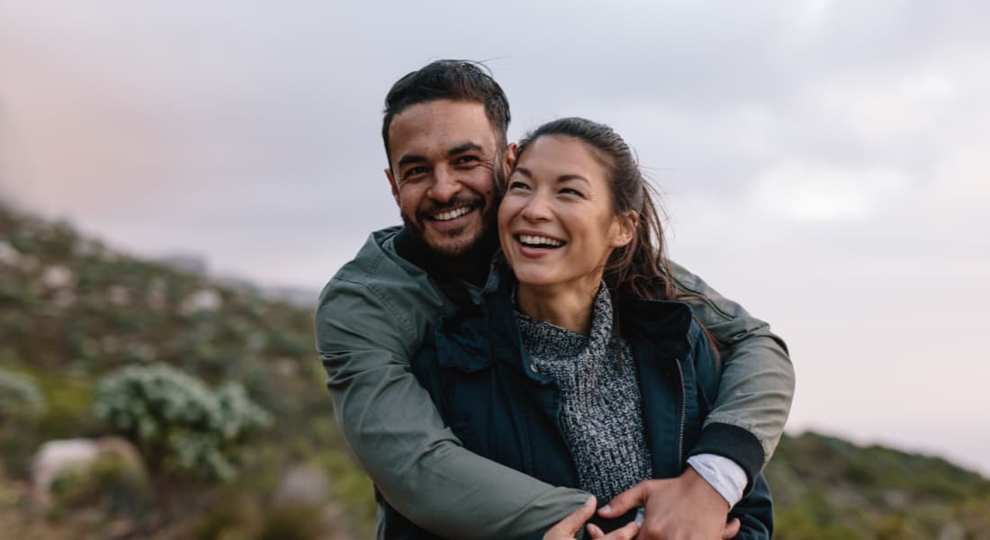 Young couple embracing on a hill