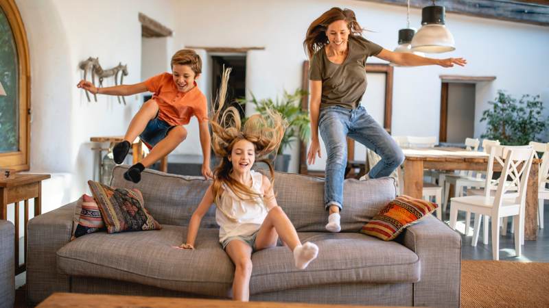 mom son daughter jumping onto couch